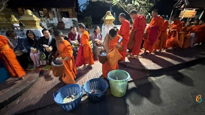 monjes depositan las ofrendas de arroz en cubos